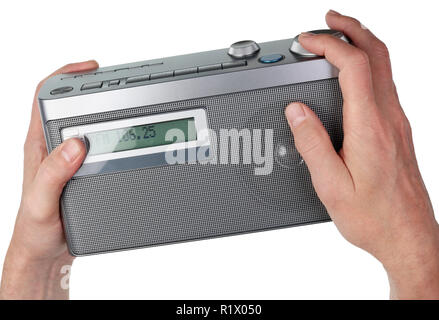 Un homme âgé avec ses doigts tuning une petite vieille pas de nom de la production de masse de l'appareil radio. Isolé sur blanc gros plan studio shot Banque D'Images