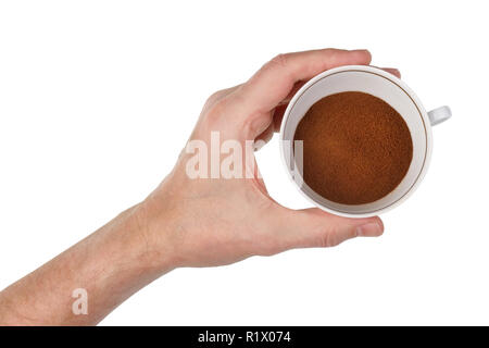 Un homme âgé tient dans sa main une tasse de porcelaine rempli de granules de café instantané. Isolé sur blanc gros plan studio shot Banque D'Images