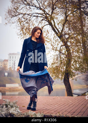 Grande fille marcher dans la ville d'automne dans un caban bleu. Banque D'Images