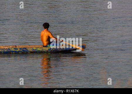 Don Det, Laos - 22 Avril 2018 : un homme en bois local aviron long boat sur le Mékong au sud du Laos Banque D'Images