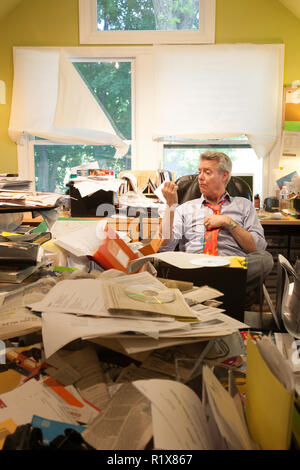 En homme d'agglomeration's Messy Home Office, USA Banque D'Images