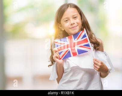 Brunette woman holding pavillon du Royaume-Uni avec un visage heureux et souriant debout avec un sourire confiant montrant les dents Banque D'Images