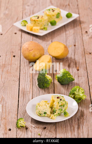 Les gratins de pommes de terre avec des fleurons de brocoli.