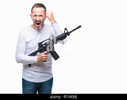 L'âge moyen des senior man holding criminelle sur fond isolé armes contrarié et frustré de crier avec colère, fou et hurlant de ra Banque D'Images