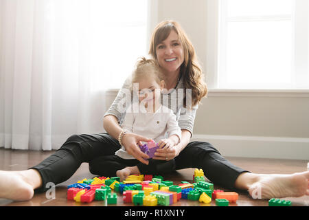 Une mère et enfant fille à partir de blocs de construction de jouets à la maison Banque D'Images