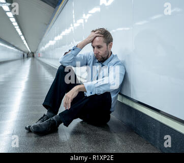 Désespérément triste jeune homme souffrant de la douleur émotionnelle chagrin et de profonde dépression assis seul dans le tunnel du métro en style de vie Stress problèmes de travail f Banque D'Images