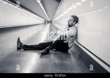 Désespérément triste jeune homme souffrant de la douleur émotionnelle chagrin et de profonde dépression assis seul dans le tunnel du métro en style de vie Stress problèmes de travail f Banque D'Images