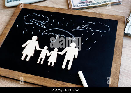 La santé et l'assurance-vie. Tableau noir avec chiffres de la famille dans l'agence. Banque D'Images
