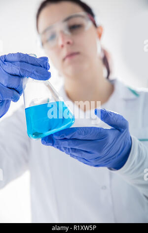 Chemist holding fiole avec un liquide bleu. Vue verticale Banque D'Images