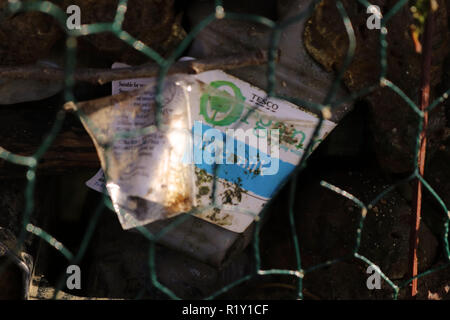 Bouteille de lait en plastique trouvé dans la Tamise pour montrer la forte utilisation de plastique utilisé dans l'environnement, tourné derrière le fil vert. Banque D'Images