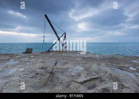 Portland Bill, Dorset, UK. 15 novembre, 2018. Météo France : un bateau grue utilisée pour soulever les petits bateaux dans et hors de la mer sur les falaises de Portland Bill est représenté comme l'aube du ciel nuageux s'éclaire. Peter Lopeman/Alamy Live News Crédit : Peter Lopeman/Alamy Live News Banque D'Images