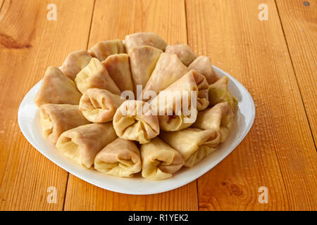 Choux farcis dans le plat blanc sur la table de bois humide Banque D'Images