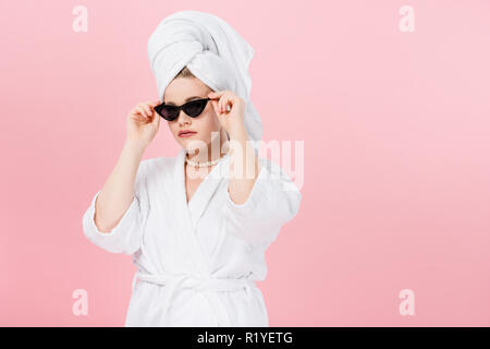 Jeune femme surdimensionnée en peignoir et serviette sur la tête lunettes réglage isolé sur pink Banque D'Images