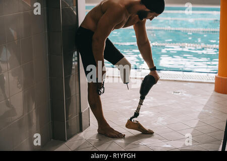 Beau jeune nageur de la piscine de piscine intérieure et décoller la jambe artificielle Banque D'Images