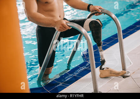 Cropped shot of athletic swimmer avec jambe artificielle en sortant de la piscine Banque D'Images