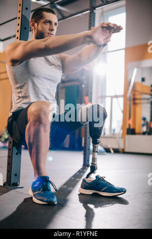 Beau jeune sportsman avec jambe artificielle working out at gym Banque D'Images