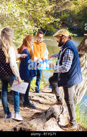 Smart Nice enfants debout devant leur guide Banque D'Images