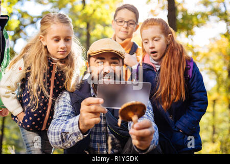 Des enfants heureux joyeux debout derrière leur professeur de biologie Banque D'Images
