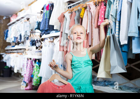 Petite fille ayant les sacs mains en magasin de v tements pour