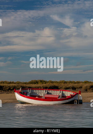 Burnham Overy Staithe sur la côte de Norfolk en bois avec un vieux bateau de pêche traditionnel ou de lancement sur le rivage en plan bloqués par la marée. Banque D'Images