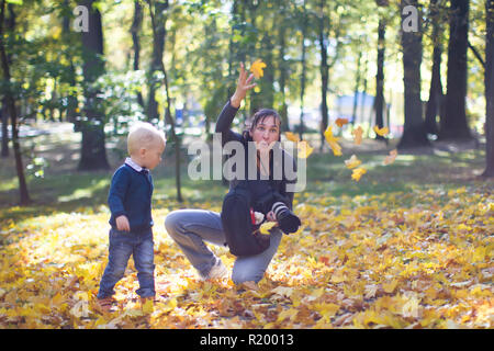 Un photographe prend des photos d'un enfant à un automne photo shoot Banque D'Images