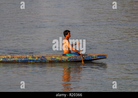 Don Det, Laos - 22 Avril 2018 : un homme en bois local aviron long boat sur le Mékong au sud du Laos Banque D'Images