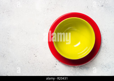 Vaisselle couleur - rouge et vert sur les plaques de lumière table de pierre. Banque D'Images