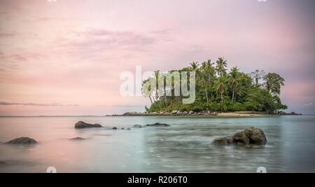 Incroyable coucher du soleil derrière une petite île, vu de la plage de Naiyang à Phuket, Thaïlande Banque D'Images