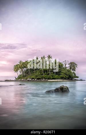 Incroyable coucher du soleil derrière une petite île, vu de la plage de Naiyang à Phuket, Thaïlande Banque D'Images