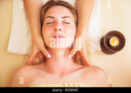 Close up portrait of a young woman getting spa treatment. Massage de la tête. Relaxed woman on massage table recevant des soins de beauté au spa de jour Banque D'Images