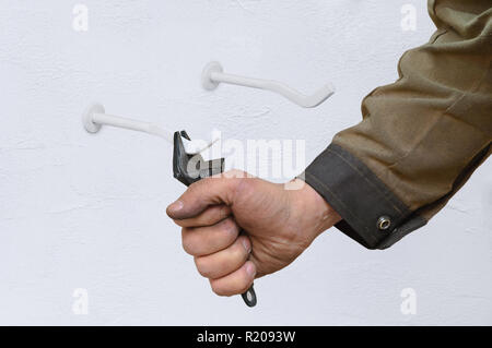 Un plombier travaillant pour le serrage Supports de radiateur sur le mur. Close-up. Banque D'Images