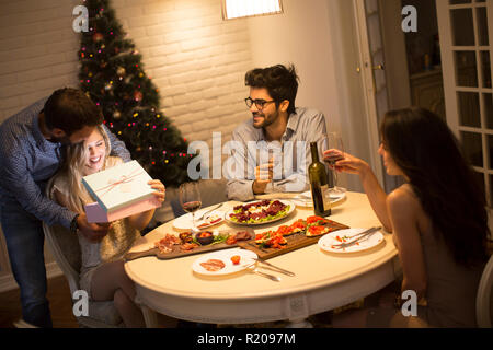 Groupe de jeunes célébration de Noël et de l'ouverture présente dans la chambre Banque D'Images