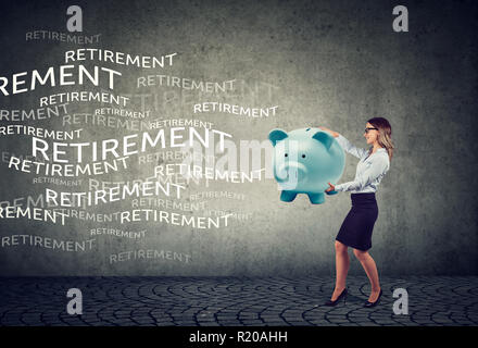 Femme d'affaires heureux d'attirer des fonds de retraite avec magnet piggy bank Banque D'Images