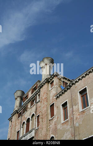 Venise, la façade de l'immeuble en brique et pots de cheminée, sur un ciel bleu Banque D'Images