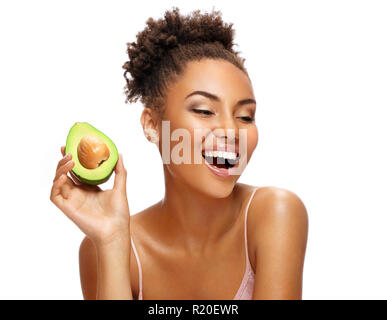 Laughing girl avec de l'avocat. Photo de african american girl with perfect skin sur fond blanc. Beauté et Soins de la peau Banque D'Images