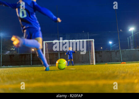Girl soccer player kicking ball vers le but Banque D'Images