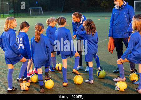 L'équipe féminine de soccer à l'écoute des entraîneurs sur terrain Banque D'Images