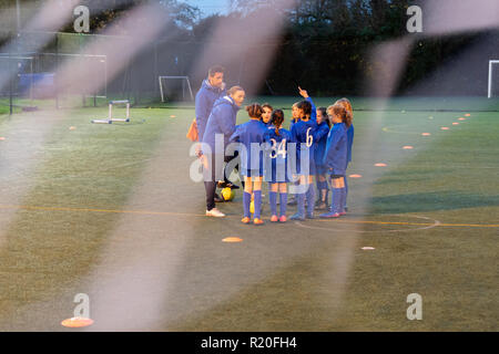 Entraîneurs de football et l'équipe de soccer girl talking on field Banque D'Images