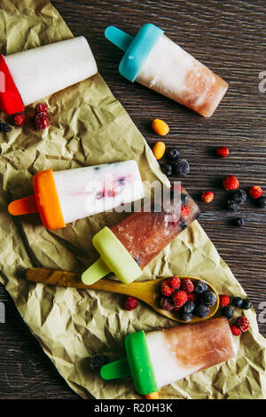 Mise à plat d'afficher beaucoup d'accueil fait un réfrigérateur smoothie jus congelé yaourt glaces avec les baies sauvages sur fond de bois sombre des. Collation santé c Banque D'Images