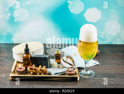 Composition plateau en bois avec différents groupe de spa essentials, beard, huile, savon argile grise éponges naturelles, bougies, huile arôme verre de bière sur Banque D'Images