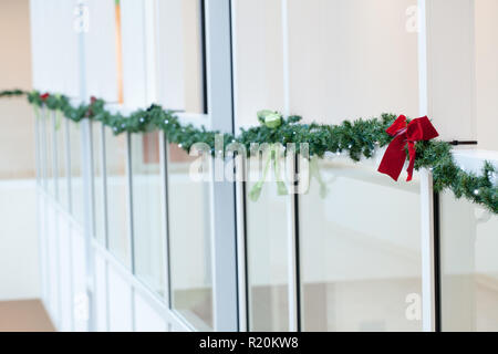 Les lumières de Noël accroché à la fenêtre avec vue sur les arbres enneigés Banque D'Images