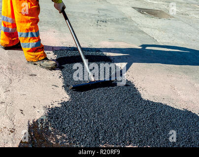 Frais de mise à niveau du travailleur au cours d'asphalte asphalte réparer ou de travaux de construction Banque D'Images
