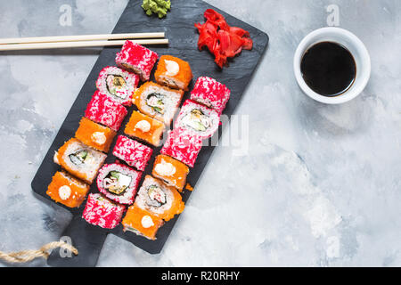 Un assortiment de rouleaux de sushi set servi sur plaque sur fond de béton. Vue d'en haut Banque D'Images