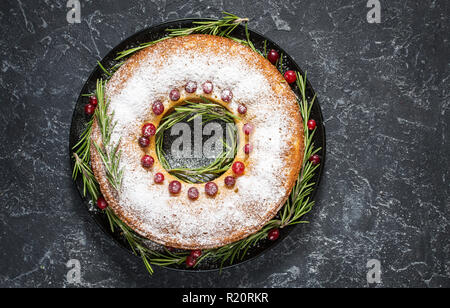 Gâteau de Noël avec baies séchées sur pierre sombre tableau. Vue d'en haut Banque D'Images