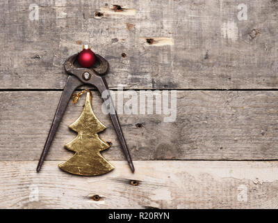 Avec une pince rouillée vieille forme de l'arbre d'or et boule de noël sur bois rustique Banque D'Images
