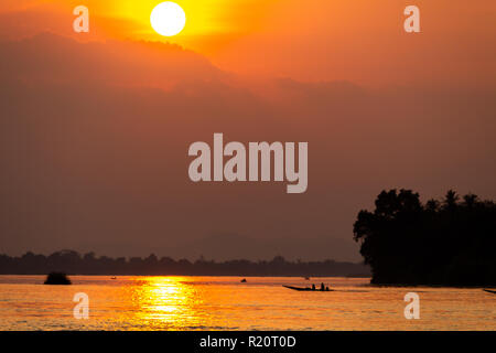 Don Det, Laos - 22 Avril 2018 : la navigation en bateau sur le Mékong au coucher du soleil vu de Don Det village près de la frontière cambodgienne Banque D'Images