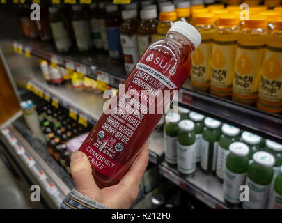 Un nouveau client inspecte une bouteille de Suja Life jus pressée à froid dans un supermarché de New York le jeudi 8 novembre, 2018. Les meilleurs pour la société jus par pression à froid aurait engagé l'Evercore investment bank d'explorer une possible vente de la marque. Coca-Cola a acquis une participation minoritaire dans l'entreprise il y a trois ans avec une option d'achat. (Â©Â Richard B. Levine) Banque D'Images