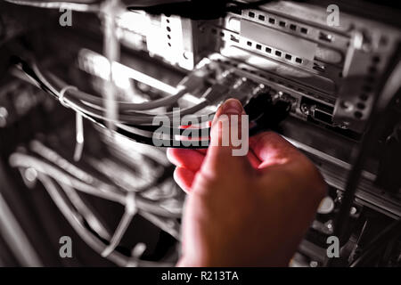 Technicien de brancher le câble de raccordement dans une montée en rack server Banque D'Images