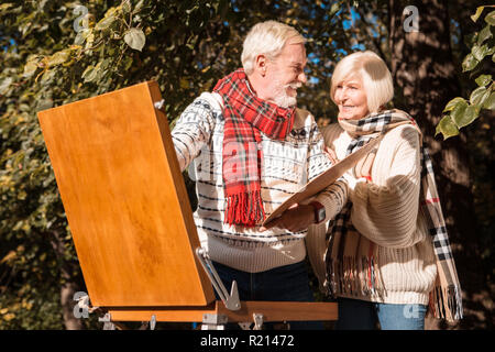 Couple heureux positive reposant ensemble dans le parc Banque D'Images