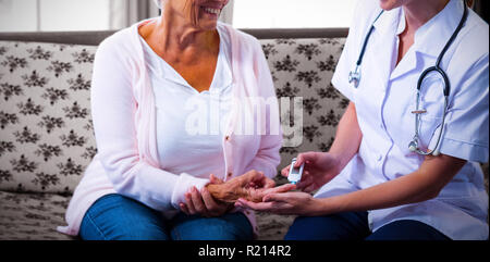 Médecin à l'essai d'un niveau de glucose chez les patients à l'aide d'un glucomètre numérique Banque D'Images